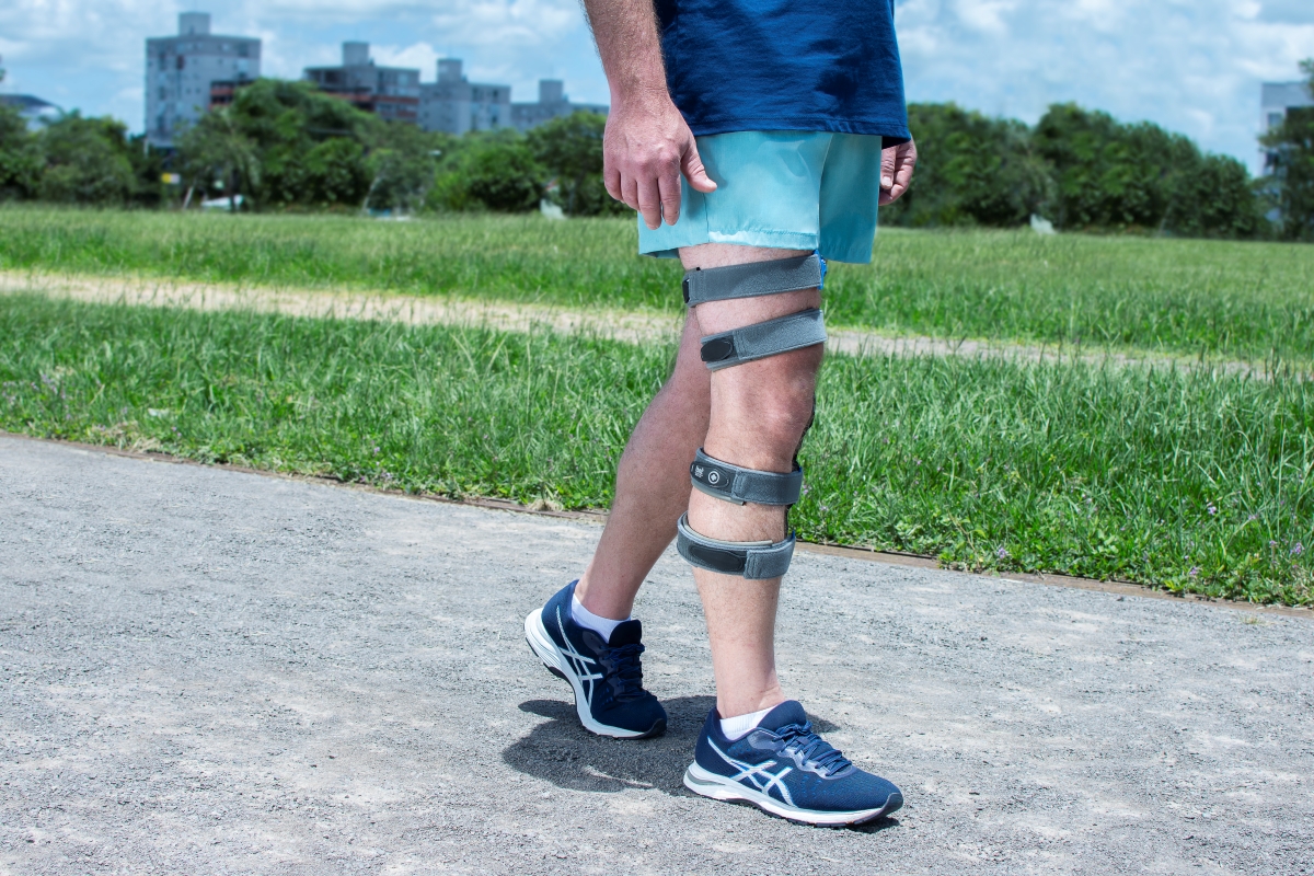 Homem caminhando com um Brace Articulado OA Xpress para joelho
